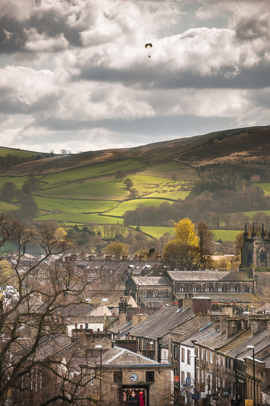 A hang glider drifting by high above Skipton